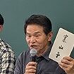 菅野正寿(すげのせいじゅ)さん<br>農家。福島県二本松市東和町。原発事故以降、外部からもオープンに人を受け入れながら、集落の力を高めてきた。この日は、おもむろに「案山子」と書いた札を取り出すと「読めるかい？」と笑いを誘い、「山の神様を案内する子ども」と収穫を喜び合うカカシの稲作文化を語ってくれた。