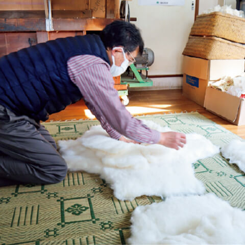 座布団用に綿を仕立てているところ。四隅を切って真ん中にのせて厚みを持たせ、折り畳んでいく
布団の仕立ても同じ要領。側（布）にきちっと入れるのにもコツがいります
